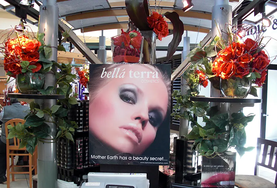 BELLATERRA poster reading Mother Earth has a beauty secret on a kiosk decorated with red roses