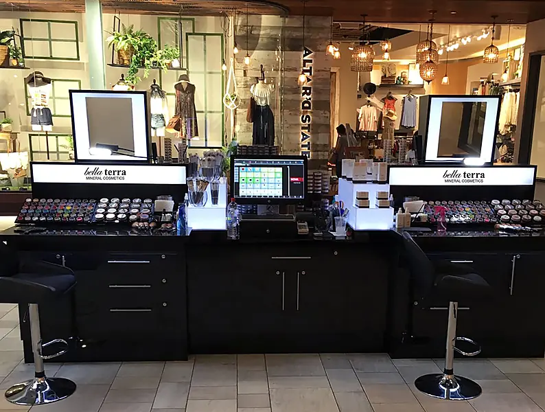 BELLATERRA mineral makeup kiosk with lit mirrors, stools and a checkout screen